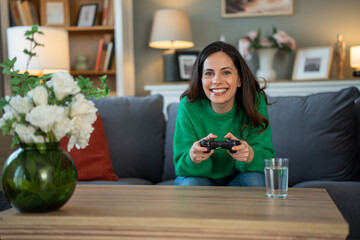 Woman smiling while enjoying video game at home © Jelena