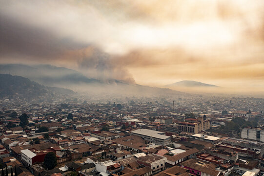 Aerial view of the Uruapan wildfire spreading smoke over the city rooftops and surrounding hills in Uruapan, Michoacan, Mexico.