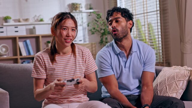 Couple argument conflict relationship on sofa in home living room, communication between woman and man during tense issue before relaxed video game weekend