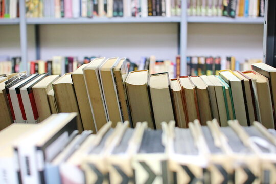 stack of books against the background of library, stack of books in front of library, books on wooden table, education, High quality book photography, Best Book Photo
