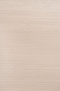 Clean close-up of a decorative plaster wall surface with fine horizontal stripe relief pattern in warm beige and cream tones, suitable as a minimal background