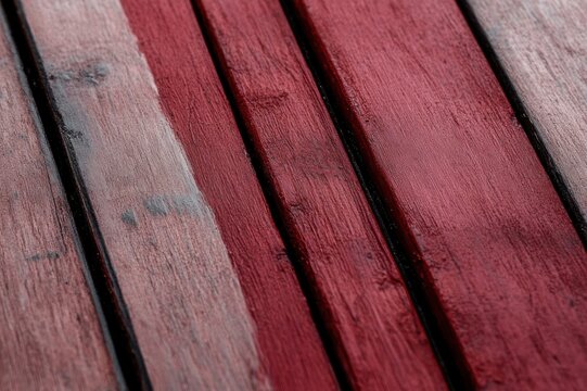 close-up of weathered red wooden planks with textured paint, dark grooves and a rustic warm mood
