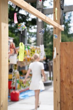 Summer vibes in Japan with traditional glass wind chimes and a tourist exploring a festival