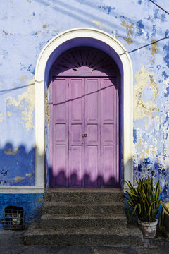 Purple colonial door on a weathered blue wall, Cartagena, Colombia
