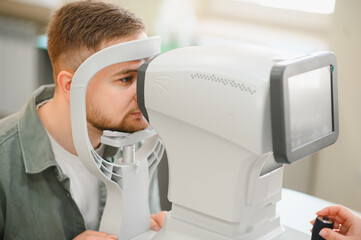 Man having eye exam with optometrist diagnostic equipment