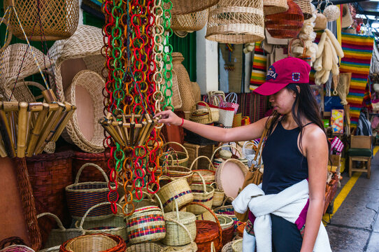 Woman browsing woven baskets at a handicraft market, Bogota, Colombia