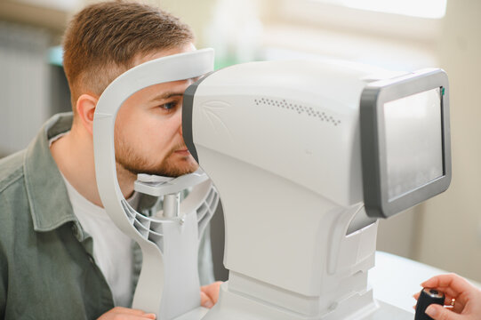 Man having eye exam with optometrist diagnostic equipment