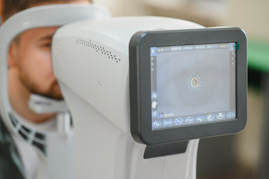 Man undergoing eye exam on autorefractor machine for vision testing