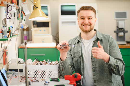 Optician technician repairing eyeglasses in workshop