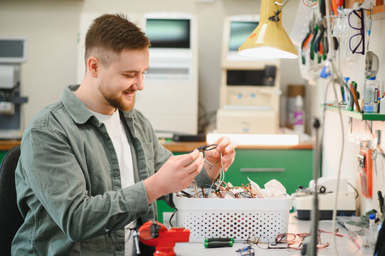Optician repairing eyeglasses at workshop workbench