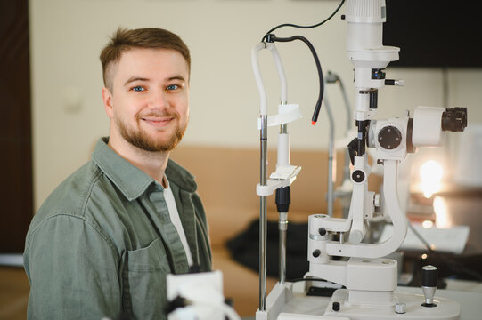 Young man smiling during vision test at eye clinic