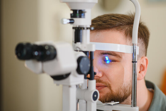 Patient receiving eye exam with slit lamp machine