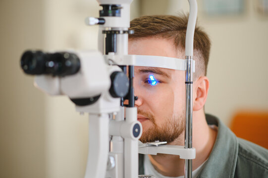 Man getting eye exam using slit lamp at ophthalmology clinic