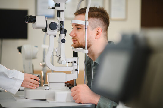 Man having eye exam with ophthalmologist using slit lamp