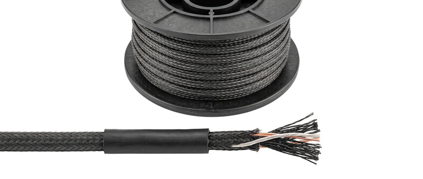 Black braided electric cable spool with stripped copper wire conductors for industrial hardware, audio equipment, wiring connections, and electrical components isolated on black background studio shot