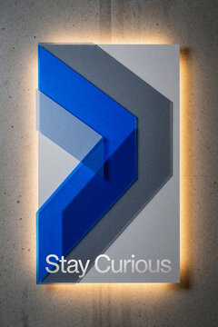 Stay Curious - Abstract geometric wall art with blue and grey chevron shapes on concrete background