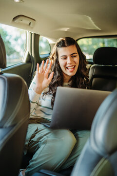 Young woman having video call on laptop while traveling