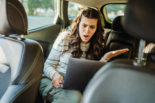 Woman experiencing technology failure with laptop in car