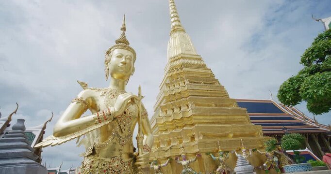 Wat Phra Kaew Temple that houses an ancient Emerald Buddha with golden angel Bangkok Thailand
