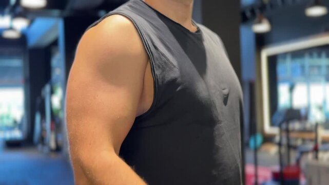 A close up video of an athletic man performing dumbbell curls and hammer curls in a gym, highlighting biceps muscle contraction, proper form, and intense arm strength training.