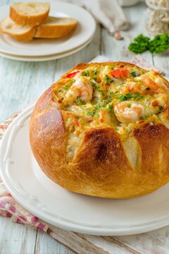 Creamy seafood chowder with prawns served in a bread bowl.