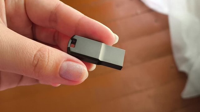USB flash drive held in hand close up, external data storage, digital memory and information technology concept.