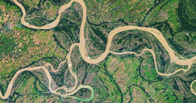 Panoramic shot on meanders of river in agricultural region with many parcels of land. Camera is moving right and down. Animation based on image by NASA