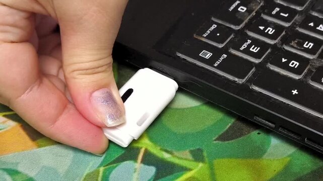 Woman disconnecting USB flash drive from laptop, external data storage, digital files and information technology concept.