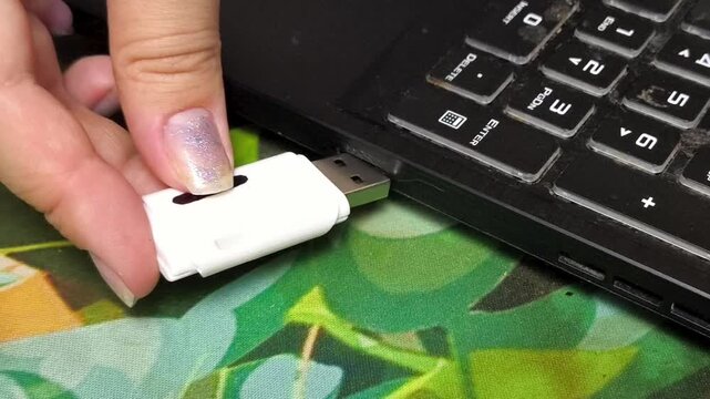 Woman connecting USB flash drive to laptop, transferring files and digital information, data storage and technology concept.