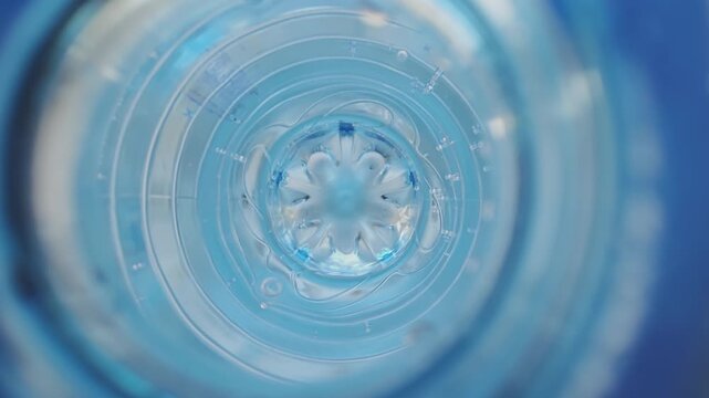 Macro view of a spinning vortex inside a plastic water bottle. Clear mineral water swirling, creating a mesmerizing whirlpool effect
