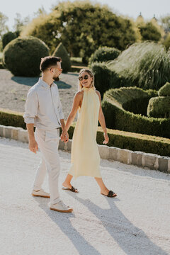 Couple enjoys a sunny stroll in a beautifully manicured garden setting