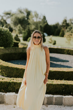 Sunny afternoon stroll in a beautiful garden with a joyful woman