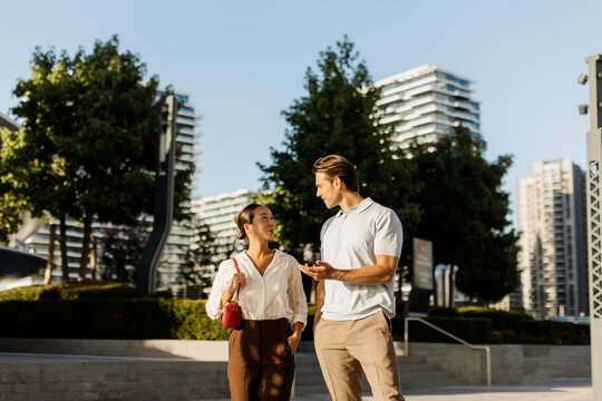 Couple shares a joyful conversation in an urban park on a sunny day