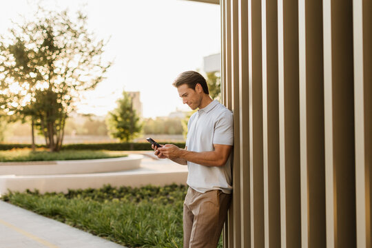 Man enjoying a peaceful moment while using his phone in a sunny garden