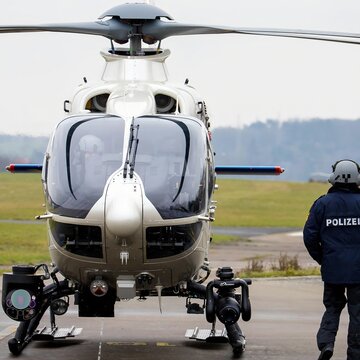 Police helicopter with mounted equipment on tarmac