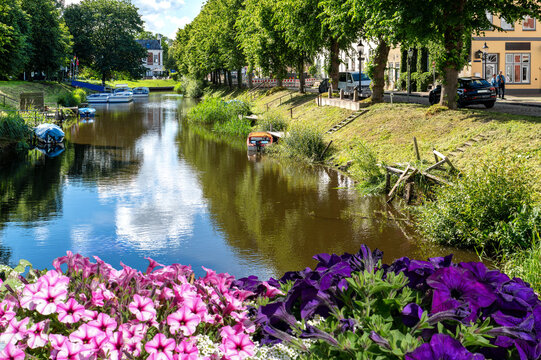 Blooming waterfront along the historic canal in Friedrichstadt, Schleswig-Holstein. Water reflections, small boats and charming architecture make this canal town a popular destination