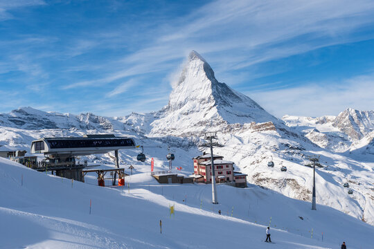 Winter view of the Matterhorn rising above ski lifts and groomed snowy slopes near Zermatt, Switzerland.