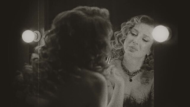 Black and white film color old style happy retro lady back rear view looking into mirror enjoying her reflection touches up makeup. sexy woman smiling beauty face burlesque show. flapper girl 20s