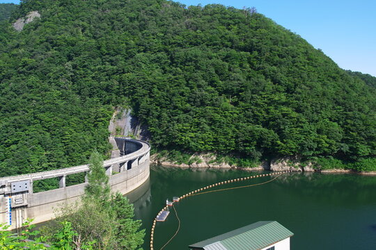 Scenic view of Naruko Dam and arch concrete dam with reservoir surrounded by green mountains in summer
