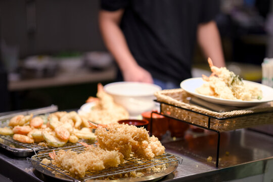 Crispy tempura shrimp on cooling racks at a food stall