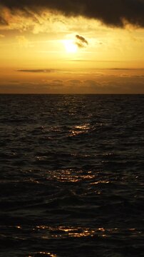 Sunset, Ocean, Reflection: Dramatic golden reflection path on dark ocean waves at majestic cloudy twilight.