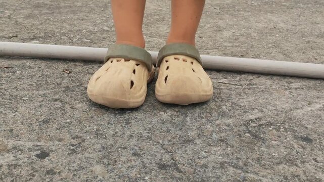 Comfortable Crocs-style casual footwear placed outdoors, featuring a lightweight design, ventilation holes, and a practical slip-on style. Suitable for everyday wear, outdoor activities, home use, and