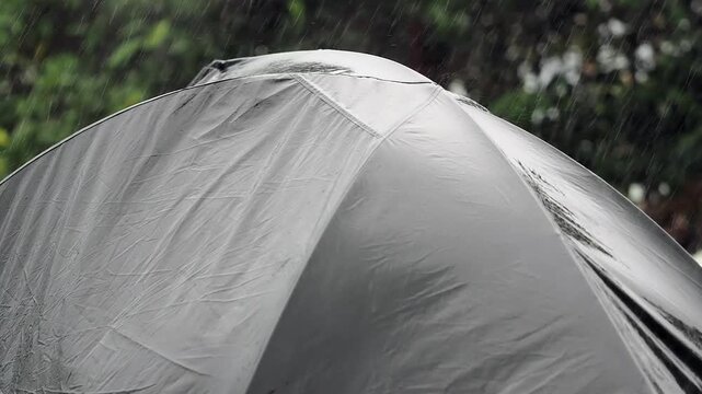 A grey camping tent featuring a waterproof design for wet conditions and an outer layer coated with synthetic material to prevent leaks.