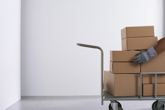 Courier Worker Moving Cardboard Packages with Hand Truck for Delivery Service