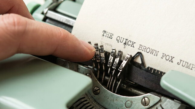 Close Up of Writer Finger Fixing Jammed Typebars on Vintage Mint Green Typewriter
