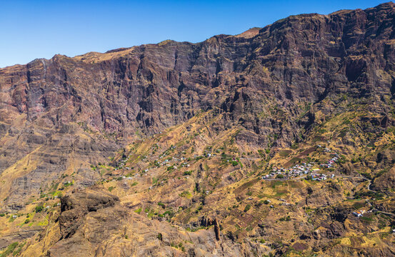 Aerial view of the rugged volcanic landscape of Santo Antao, featuring terraced agricultural fields and small settlements nestled in the deep valleys of Alto Mira, Porto Novo, Cabo Verde.