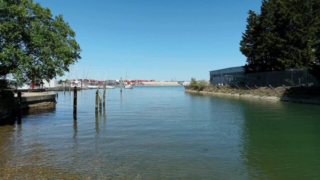 Low aerial view over water revealing commercial port and expansive bay in Southampton UK