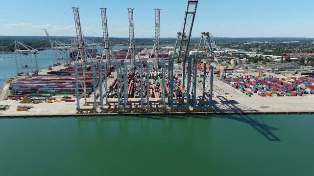 Close-up drone shot of giant STS gantry cranes over stacked shipping containers at Southampton dock