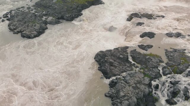 Aerial view of flowing Urridafoss waterfall and volcanic