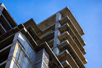 Fototapeta premium Unfinished Concrete Building Structure Against Blue Sky